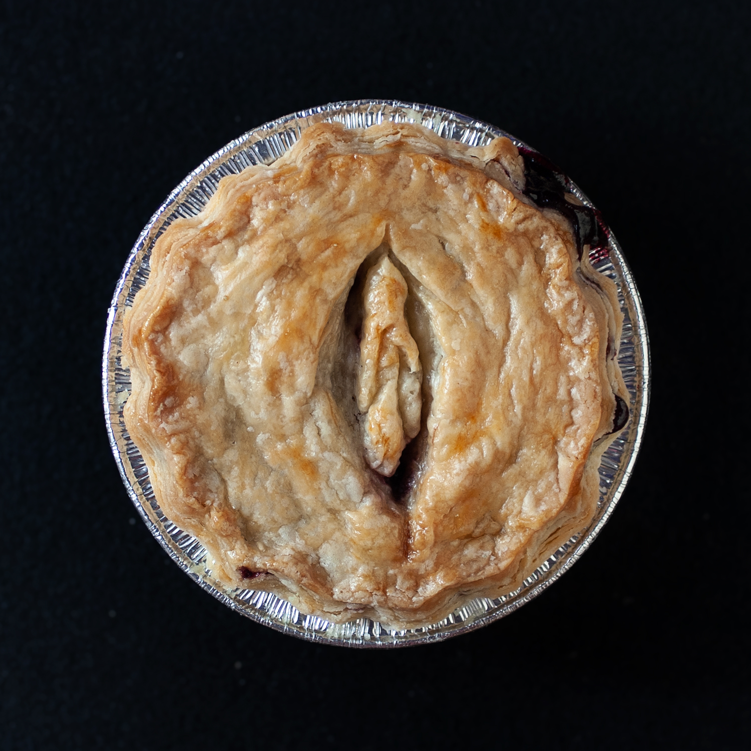 Baked pie that has a vulva pie crust decoration