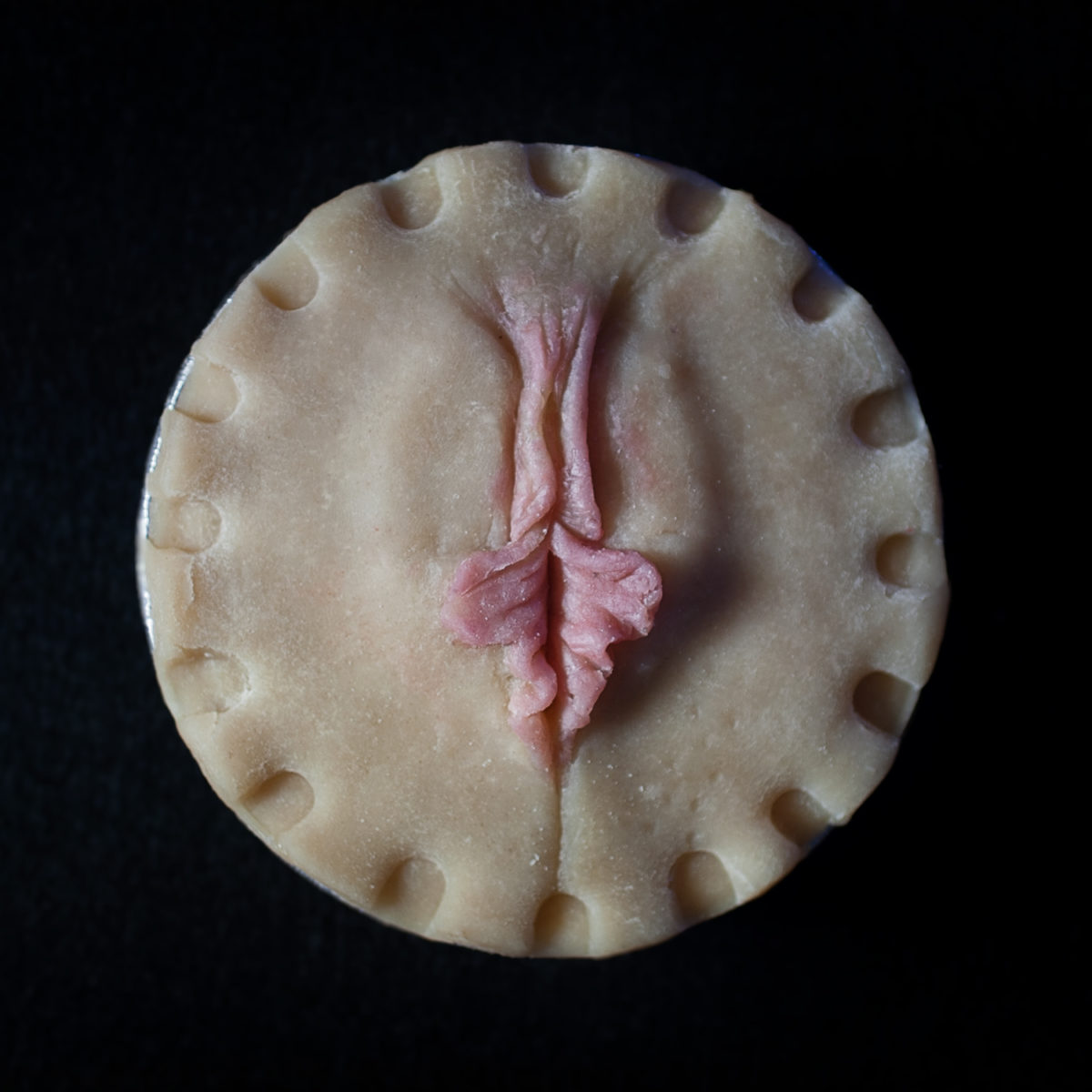 Pie crust art that looks like a vulva with pink inner labia protruding to represent vulva diversity