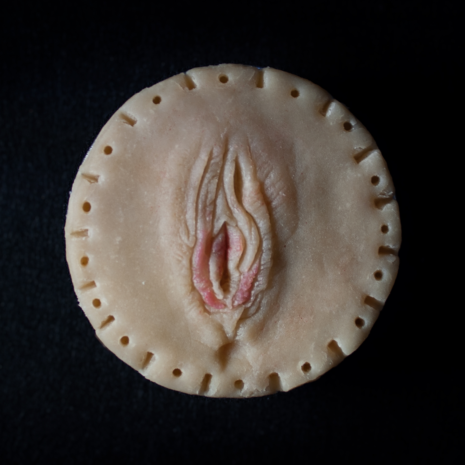 A 4 inch mini pie with a pie crust design that looks like a realistic vulva