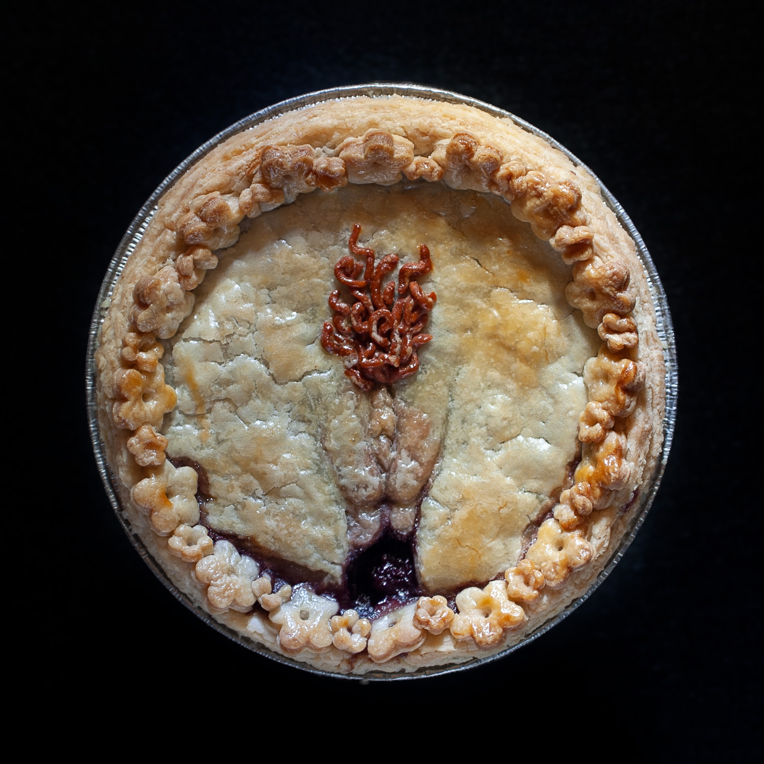 Baked six inch Cherry berry berry pie with hand sculpted pie crust art depicting a vulva with red pubic hair