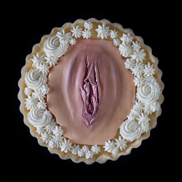 A lemon cream tart with Chantilly cream, decorated with a hand sculpted modeling chocolate vulva as part of a series of vulva tarts.