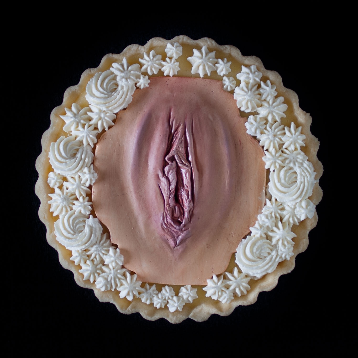 A lemon cream tart with Chantilly cream, decorated with a hand sculpted modeling chocolate vulva as part of a series of vulva tarts. 