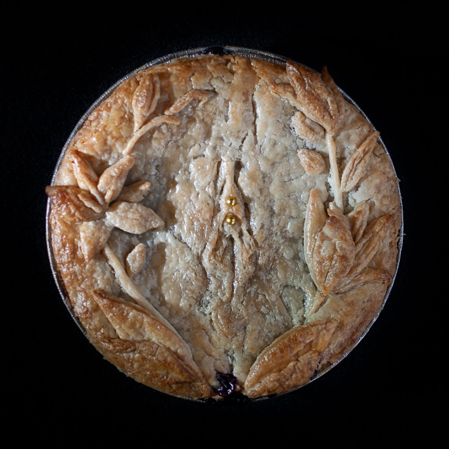 Baked vulva pie 47 with hand pie crust vulva and pie crust lilies surrounding the vulva