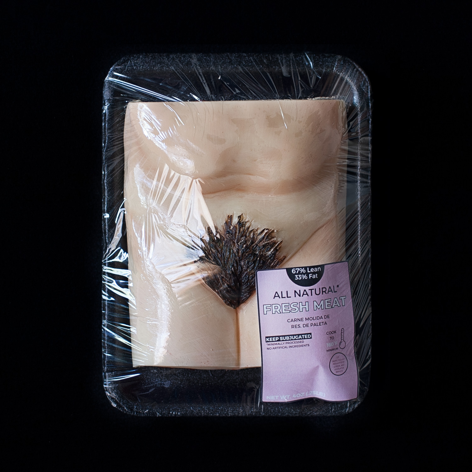 A red velvet cake decorated with hand sculpted modeling chocolate made to look like a human vulva. The cake on a black styrofoam meat tray, wrapped in plastic wrap with a pink label. 