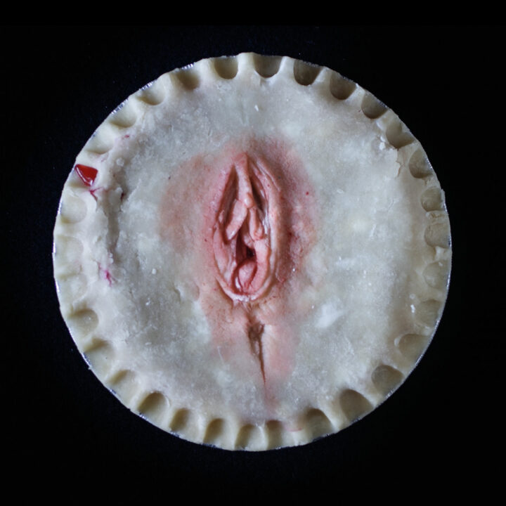 Hand made pie art that looks like a human vulva on a black background.