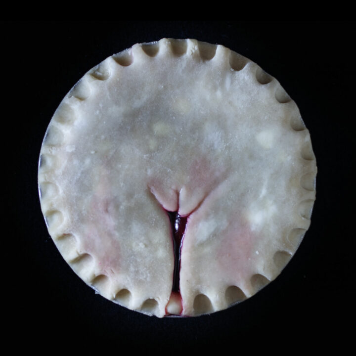 Made from scratch vulva pie on black background.