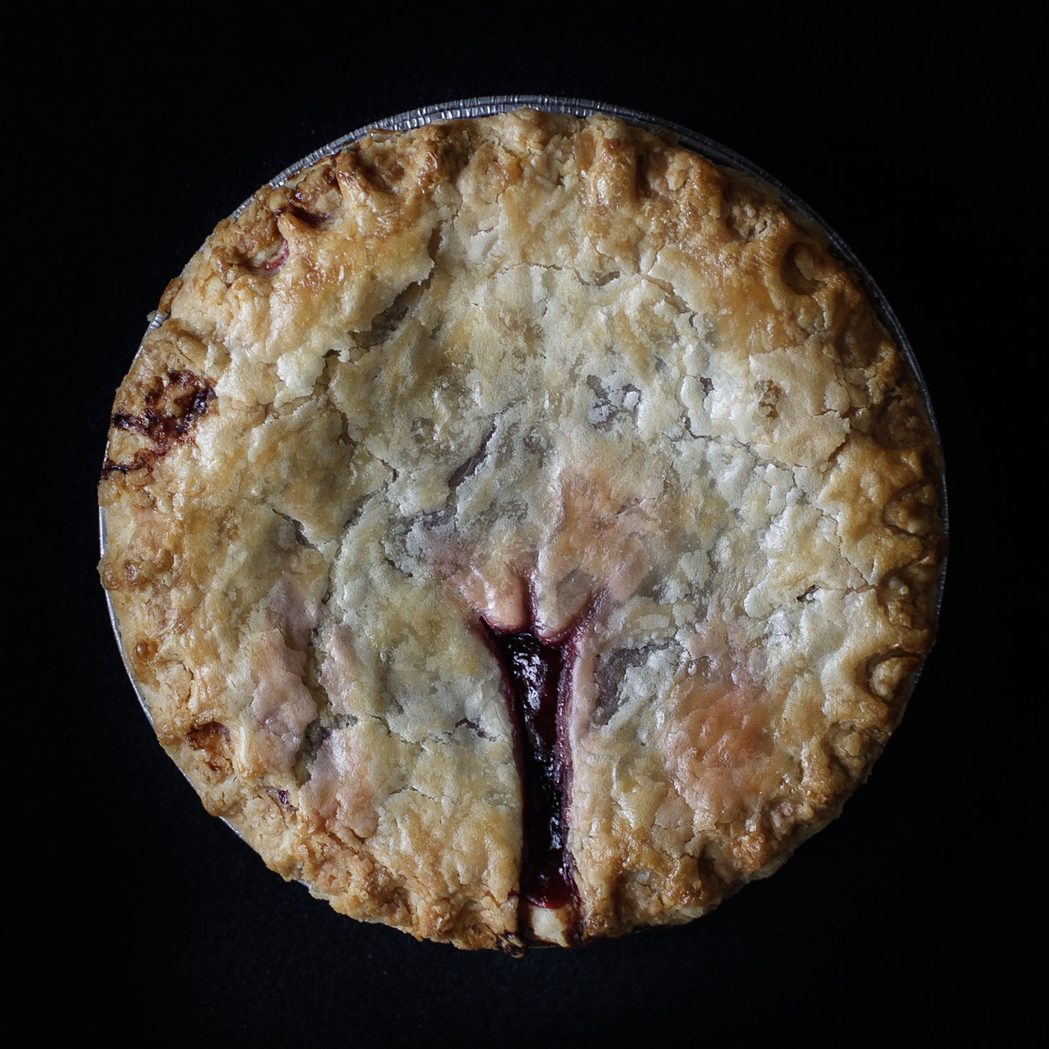 Made from scratch vulva pie on black background. 