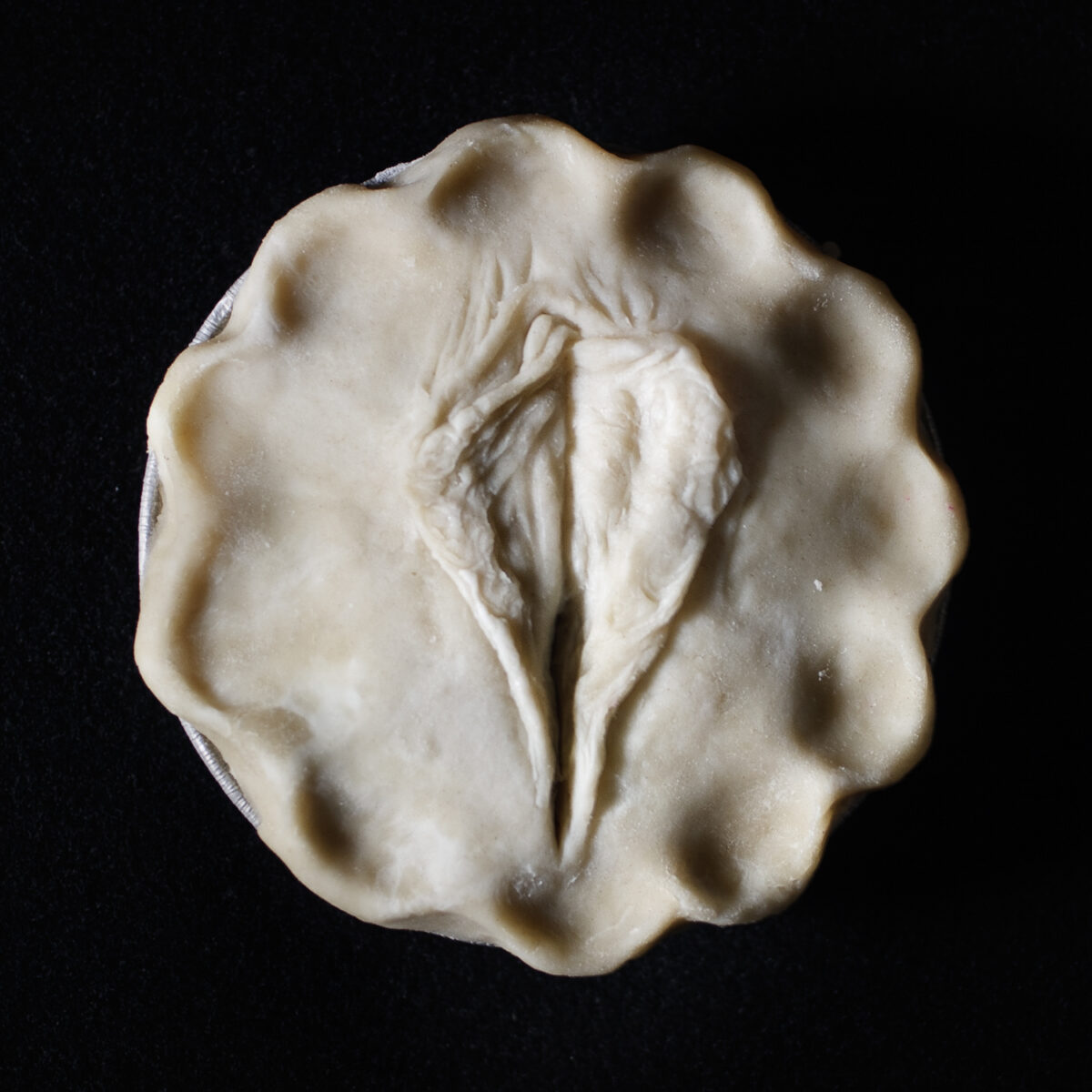 unbaked pie with art that looks like a human vulva