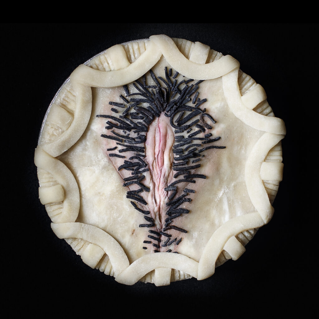 Unbaked pie vulva art on black background.